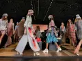 Pokaz mody BCBGMAXAZRIA. Modelki prezentują kolorowe, etniczne stroje i kapelusze na wybiegu.