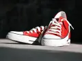 Czerwone trampki z białymi sznurówkami. Ich tęgość obuwia jest idealna do codziennych spacerów.