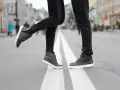 Para, jak zapobiec farbowaniu butów? Stylowe brązowe sneakersy na miejskim przejściu dla pieszych.