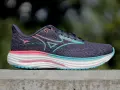 Buty do biegania Mizuno Wave Rider 27 w kolorze fioletowym z różowymi i turkusowymi akcentami. Mizuno to znana japońska marka odzieży sportowej.
