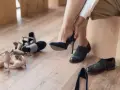 Kobieta przymierza granatowe szpilki. Wokół leżą inne buty. Wkładka 25 cm jaki to rozmiar?