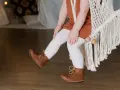 Małe nóżki w brązowych bucikach, idealne na spacer. Jaki to rozmiar buta dziecka?