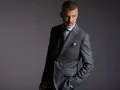 Elegancki mężczyzna w garniturze w kratę. Czy to Dressmann? To firma oferująca modną odzież męską.