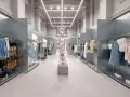 Nowoczesne wnętrze sklepu Bershka z wieszakami pełnymi ubrań i manekinem w centrum.
