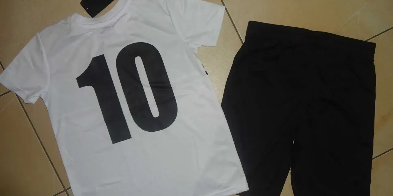 Biała koszulka z czarną "10" i czarne spodenki. Metka z napisem "Chapter Young" sugeruje, że to firma odzieżowa.