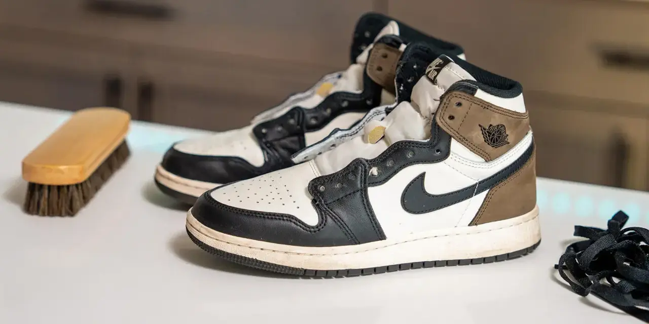 Para wiedzą, czy buty Nike można prać w pralce, leżą obok szczotki do czyszczenia i sznurówek.