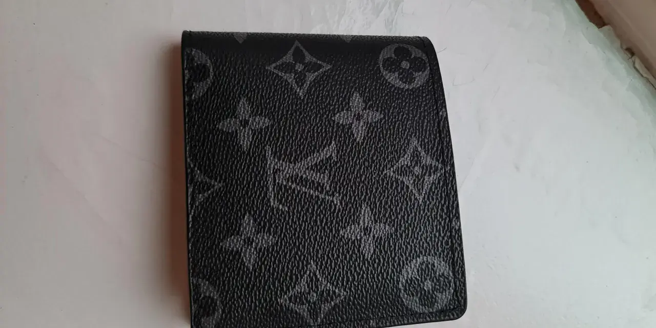 Czarny portfel Louis Vuitton z monogramem na jasnym tle.