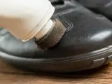 Domowe sposoby na rysy na butach: aplikacja pasty do butów za pomocą gąbki.