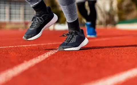 Biegacze na bieżni. Widoczne buty sportowe, podkreślające ruch stopy, czyli supinację i pronację.