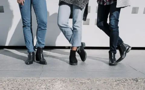 Trzy pary damskich jeansów i różne buty: botki na obcasie, zamszowe botki i eleganckie botki. Idealne inspiracje, jakie buty do jeansów damskich wybrać.