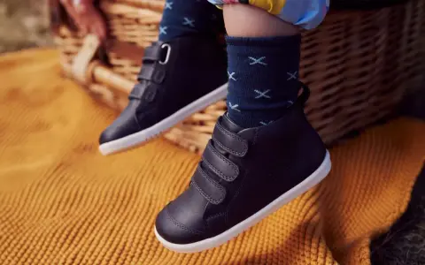 Dziecięce buty zimowe na rzepy, na tle koszyka piknikowego i koca.