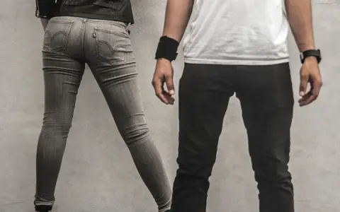 Szara, dopasowana para jeansów, widać metkę Levi's. Czy to rozmiar w25? Obok mężczyzna w czarnych spodniach.