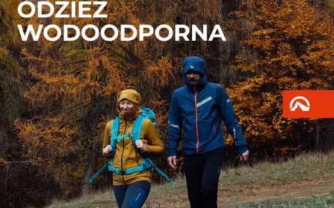Para idzie przez jesienny las w odzieży wodoodpornej. To oferta firmy Northfinder, która specjalizuje się w odzieży outdoorowej.