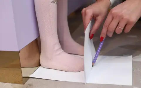 Dziecko mierzy stopę, by dowiedzieć się, jaki to rozmiar buta. 15 cm to idealny pomiar dla małych stópek.