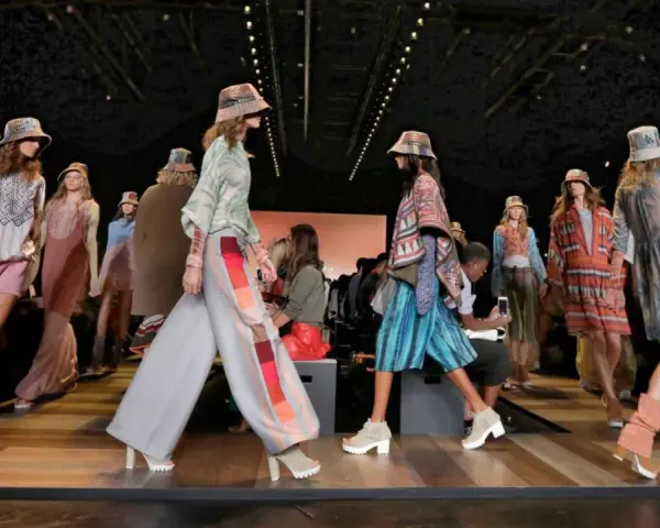 Pokaz mody BCBGMAXAZRIA. Modelki prezentują kolorowe, etniczne stroje i kapelusze na wybiegu.