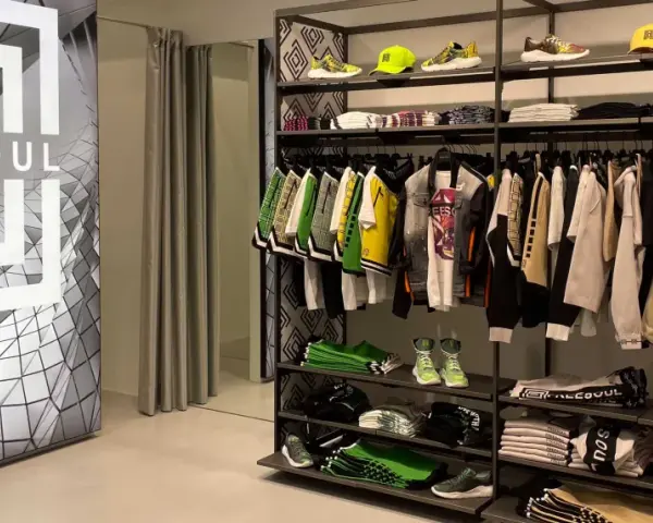 Sklep z odzieżą freesoul co to za firma. Widać ubrania i buty tej marki, a także logo freesoul na ścianie.