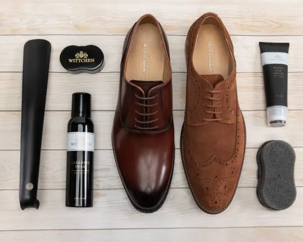 Zestaw do pielęgnacji obuwia: eleganckie brązowe i zamszowe buty, łyżka do butów, pianka czyszcząca, krem wodoodporny i gąbka. Idealny poradnik, jak pastować buty.