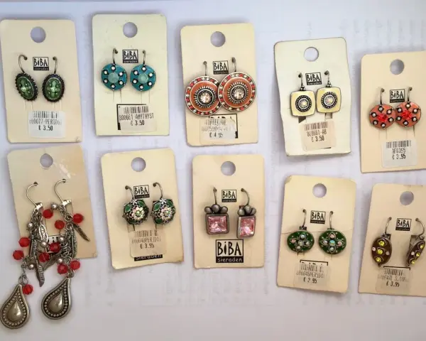 Kolczyki marki Biba Sieraden. Różnorodne wzory i kolory, od zielonych i niebieskich po pomarańczowe i różowe. Biba co to za marka? To marka biżuterii.