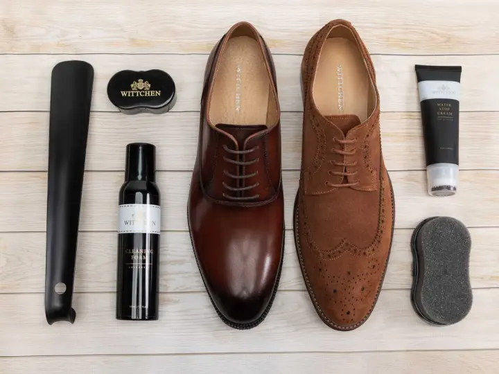Zestaw do pielęgnacji obuwia: eleganckie brązowe i zamszowe buty, łyżka do butów, pianka czyszcząca, krem wodoodporny i gąbka. Idealny poradnik, jak pastować buty.