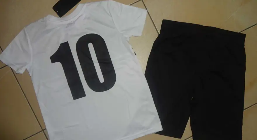 Biała koszulka z czarną "10" i czarne spodenki. Metka z napisem "Chapter Young" sugeruje, że to firma odzieżowa.