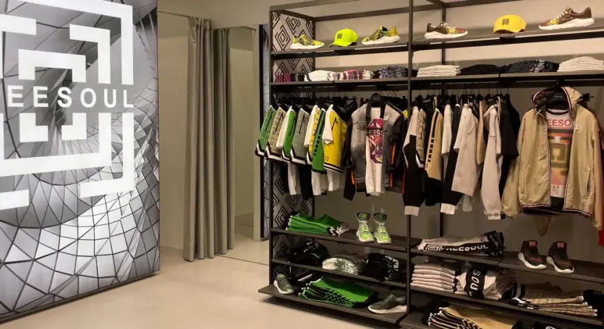 Sklep z odzieżą freesoul co to za firma. Widać ubrania i buty tej marki, a także logo freesoul na ścianie.