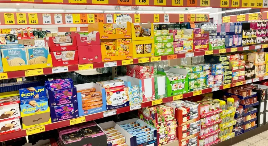 Półki sklepowe uginają się od słodkości, ciastek i herbat. Widać tu wiele produktów marki newcential, w tym ciastka, wafle i herbaty w atrakcyjnych cenach.
