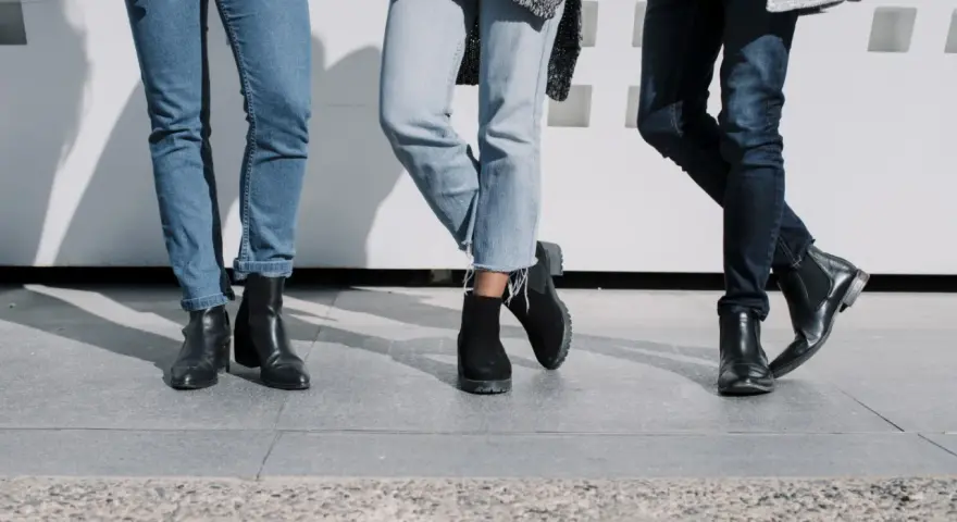Trzy pary damskich jeansów i różne buty: botki na obcasie, zamszowe botki i eleganckie botki. Idealne inspiracje, jakie buty do jeansów damskich wybrać.